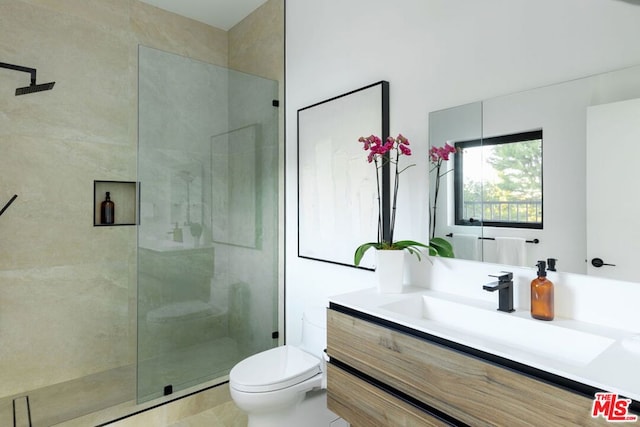 bathroom featuring toilet, a shower with door, and vanity