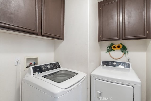 washroom with cabinets and washer and dryer