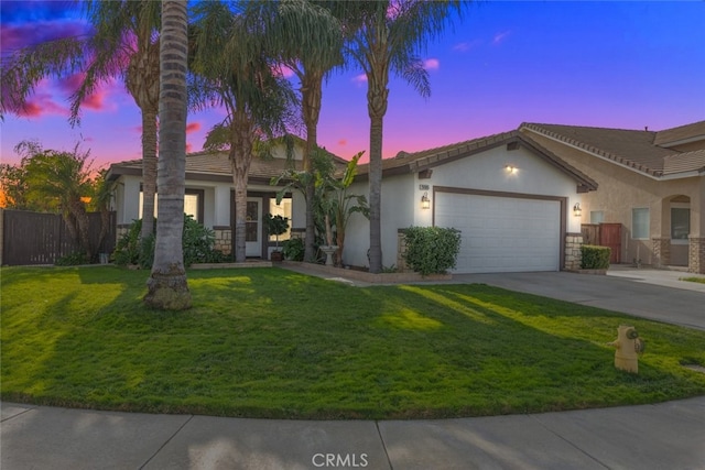 view of front of property with a garage and a lawn