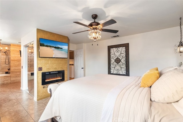 bedroom with light tile patterned floors, ceiling fan with notable chandelier, and a fireplace