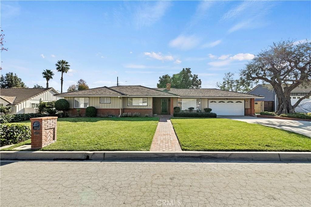 ranch-style house featuring a front yard and a garage