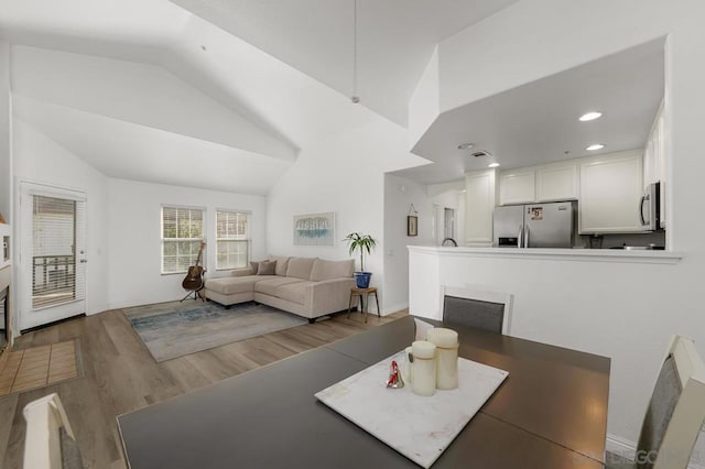 dining room featuring vaulted ceiling and hardwood / wood-style flooring