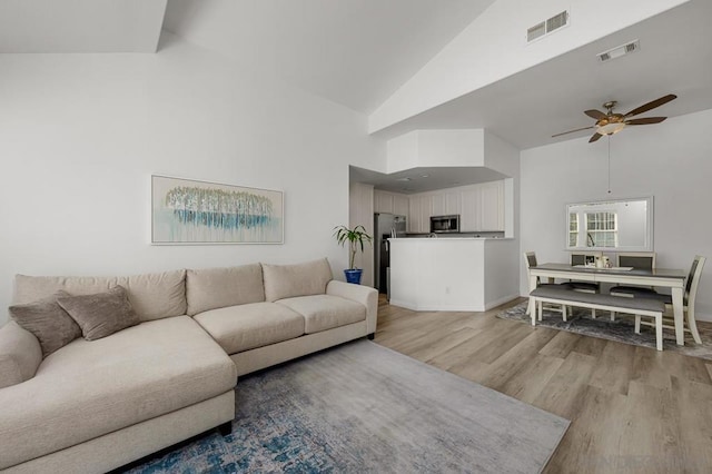 living room featuring high vaulted ceiling, ceiling fan, and light hardwood / wood-style floors