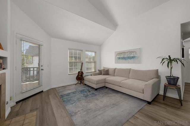 living room featuring lofted ceiling, plenty of natural light, and light hardwood / wood-style flooring