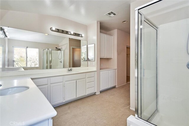 bathroom featuring vaulted ceiling, a shower with shower door, and vanity