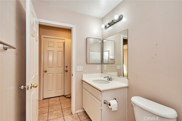 bathroom with toilet, tile patterned flooring, and vanity