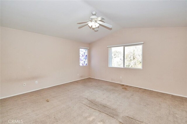 carpeted spare room with ceiling fan and vaulted ceiling