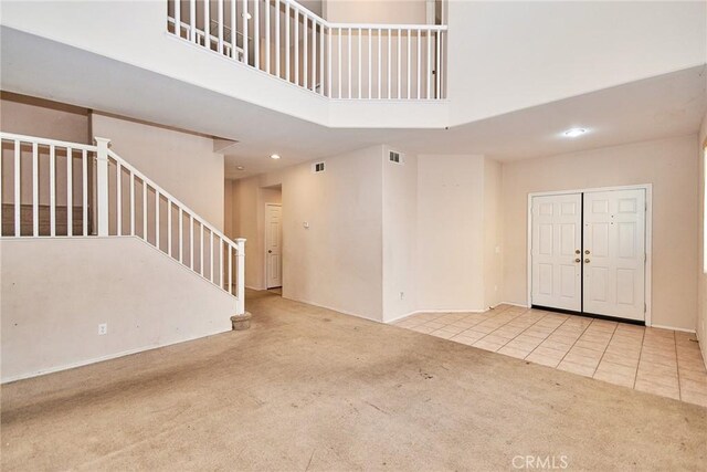 entrance foyer featuring a high ceiling and light carpet