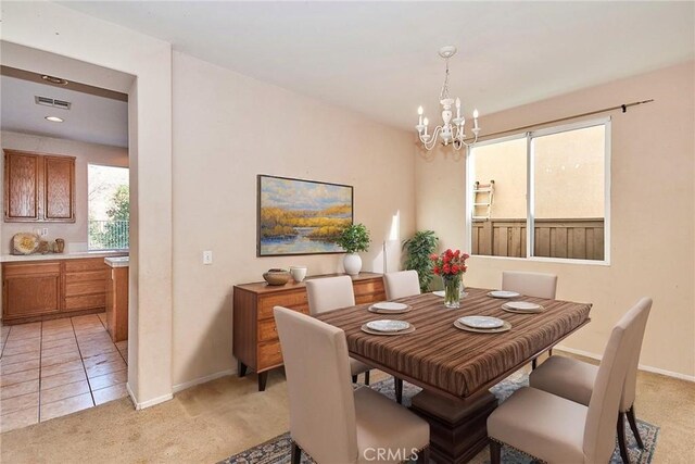 carpeted dining space featuring an inviting chandelier