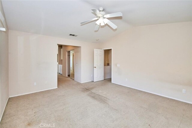 carpeted spare room featuring ceiling fan and vaulted ceiling