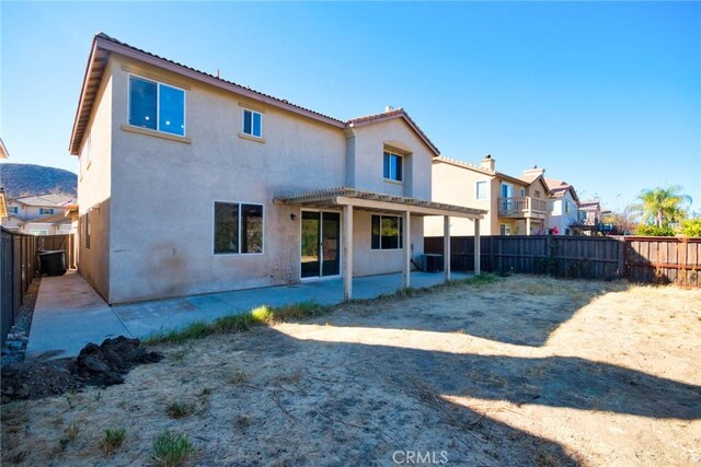 rear view of property featuring central air condition unit and a patio