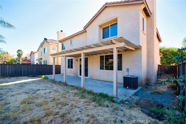 rear view of property with a patio area, central AC unit, and a pergola