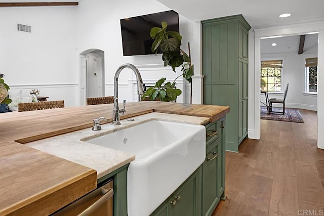 kitchen with sink, green cabinetry, lofted ceiling with beams, and dark hardwood / wood-style floors