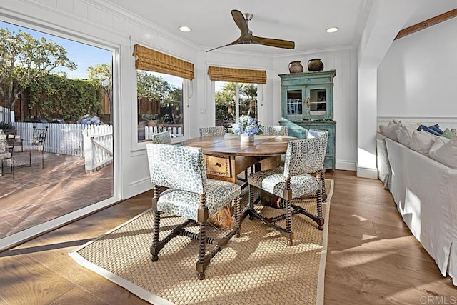 dining space with hardwood / wood-style flooring, ceiling fan, and crown molding