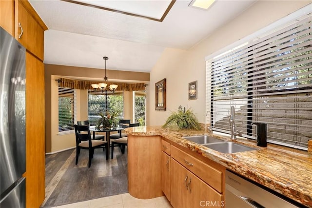 kitchen featuring stainless steel appliances, pendant lighting, plenty of natural light, sink, and an inviting chandelier