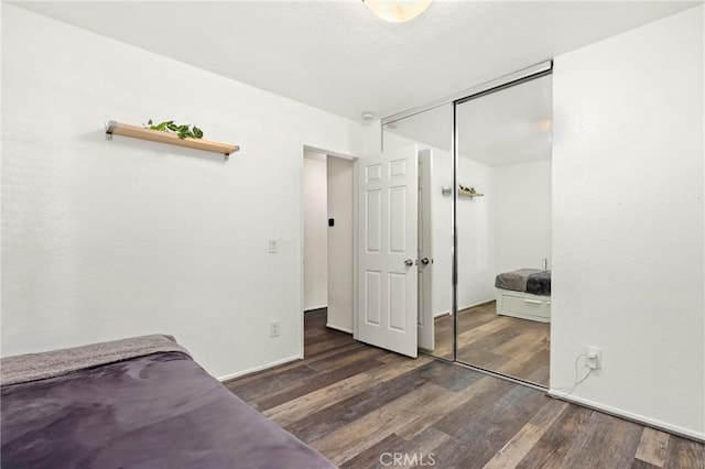 unfurnished bedroom featuring a closet and dark wood-type flooring