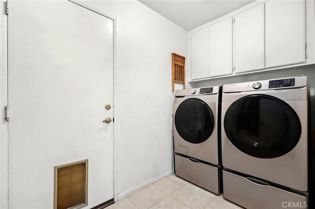 laundry area featuring light tile patterned floors, cabinets, and independent washer and dryer