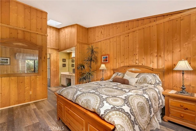 bedroom with dark hardwood / wood-style flooring, ensuite bathroom, and wood walls