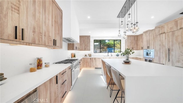 kitchen featuring decorative light fixtures, sink, light brown cabinets, and wall oven