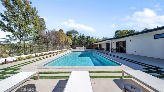 view of pool with a diving board and a patio