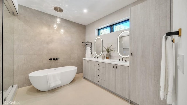 bathroom featuring tile walls, a washtub, and vanity