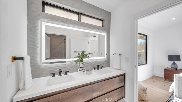 bathroom with tasteful backsplash, hardwood / wood-style flooring, and vanity