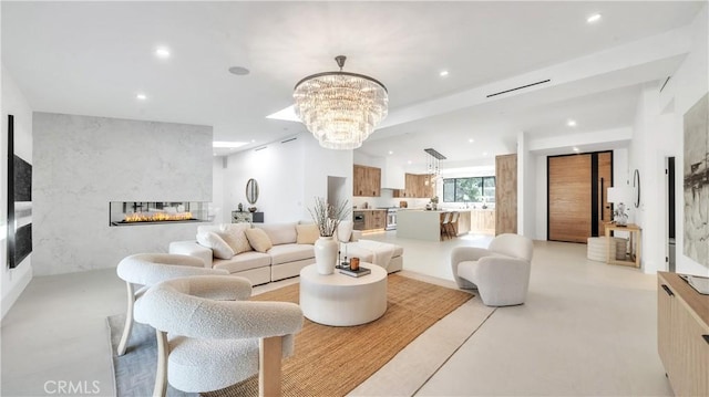 living room with a large fireplace and an inviting chandelier