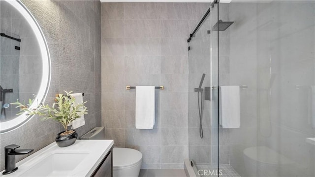 bathroom with toilet, vanity, and a shower with door