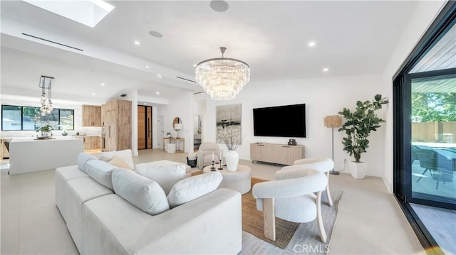 living room featuring a healthy amount of sunlight, a skylight, and an inviting chandelier