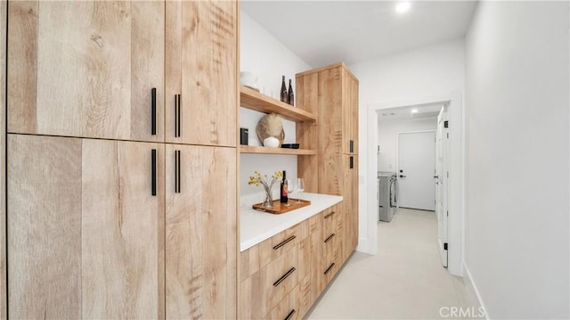 bar with light brown cabinetry and independent washer and dryer