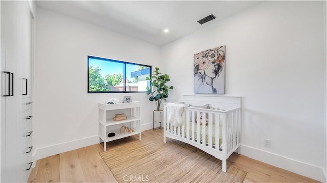 bedroom featuring a crib and hardwood / wood-style floors