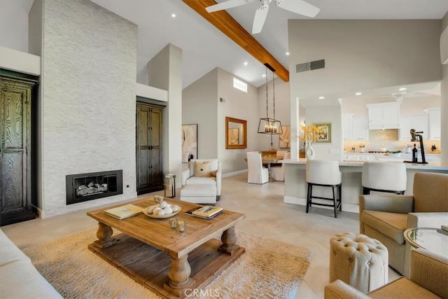 living room featuring a fireplace, light tile patterned floors, ceiling fan with notable chandelier, a high ceiling, and beam ceiling