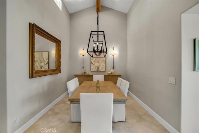 tiled dining area featuring high vaulted ceiling and an inviting chandelier