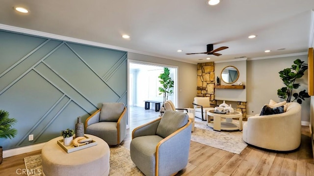 living area featuring ceiling fan, ornamental molding, and light hardwood / wood-style floors