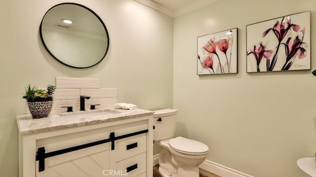 bathroom featuring toilet, vanity, and crown molding