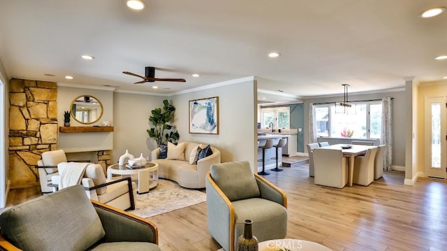 living room featuring ceiling fan, light hardwood / wood-style floors, and crown molding