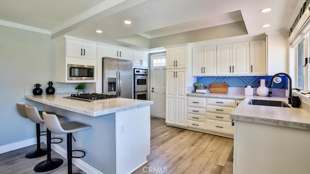 kitchen featuring light hardwood / wood-style flooring, stainless steel appliances, crown molding, white cabinets, and sink