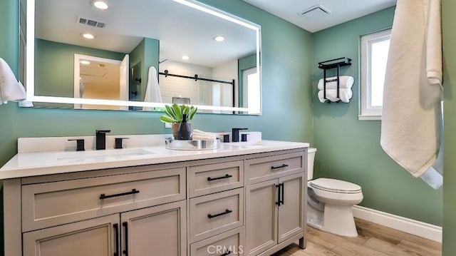 bathroom with walk in shower, vanity, wood-type flooring, and toilet