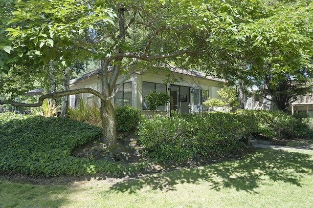 view of home's exterior featuring a lawn and a sunroom