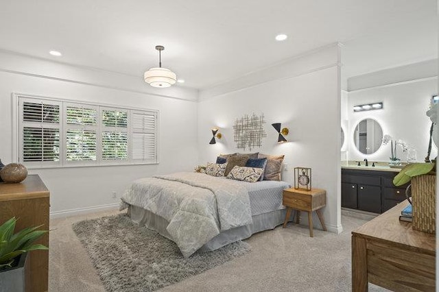 bedroom featuring sink, connected bathroom, and carpet flooring