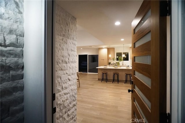 interior space featuring pendant lighting and light hardwood / wood-style flooring