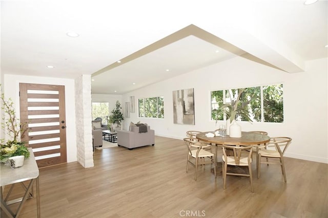 dining area with vaulted ceiling, light hardwood / wood-style flooring, and a wealth of natural light