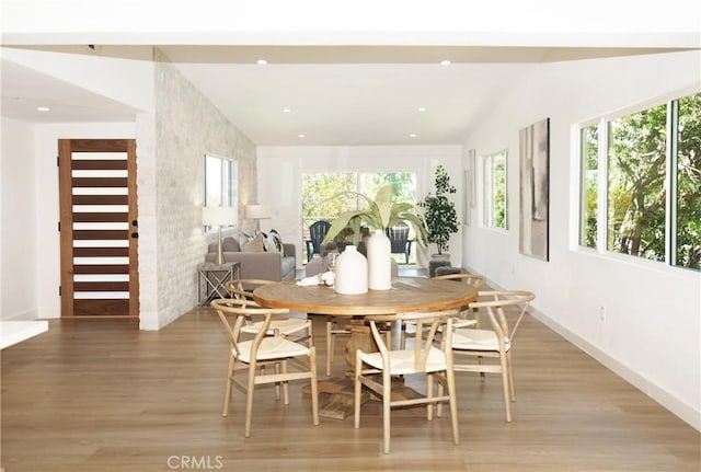 dining area featuring lofted ceiling and light hardwood / wood-style flooring