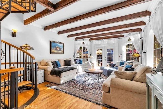 living room with light hardwood / wood-style floors, beam ceiling, and french doors