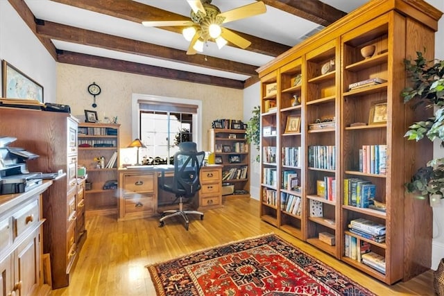 office area with light wood-type flooring, ceiling fan, and beamed ceiling