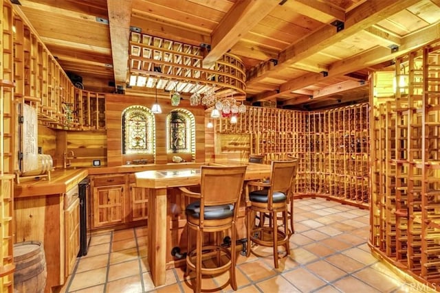 wine cellar featuring indoor bar, beamed ceiling, and wood ceiling