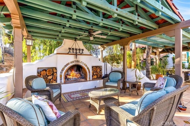 view of patio with an outdoor living space with a fireplace and ceiling fan