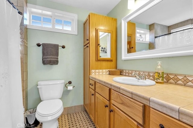 bathroom featuring decorative backsplash, toilet, and vanity