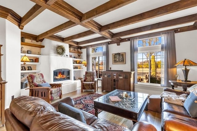 living room featuring built in shelves, coffered ceiling, beam ceiling, and hardwood / wood-style flooring