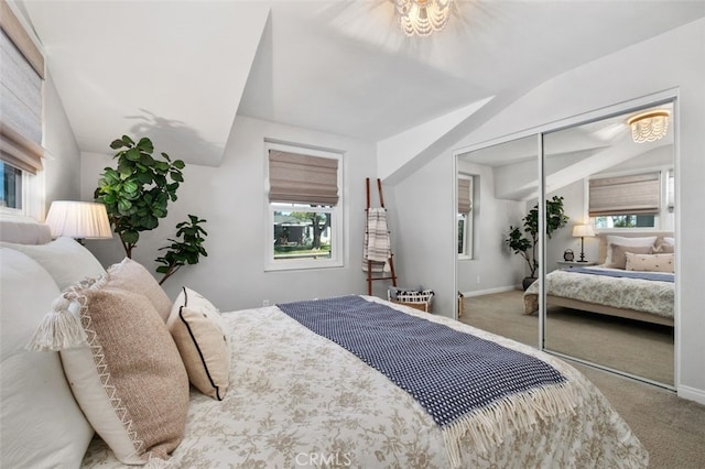 bedroom with lofted ceiling, a closet, and carpet flooring